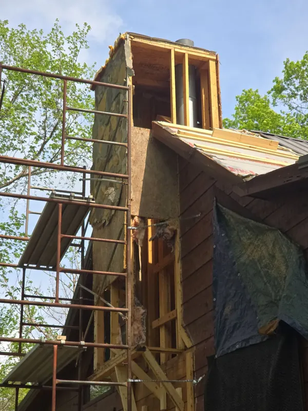 Chimney chase on a log-sided home near Aurora, KY stripped to its framing, worked from scaffolding