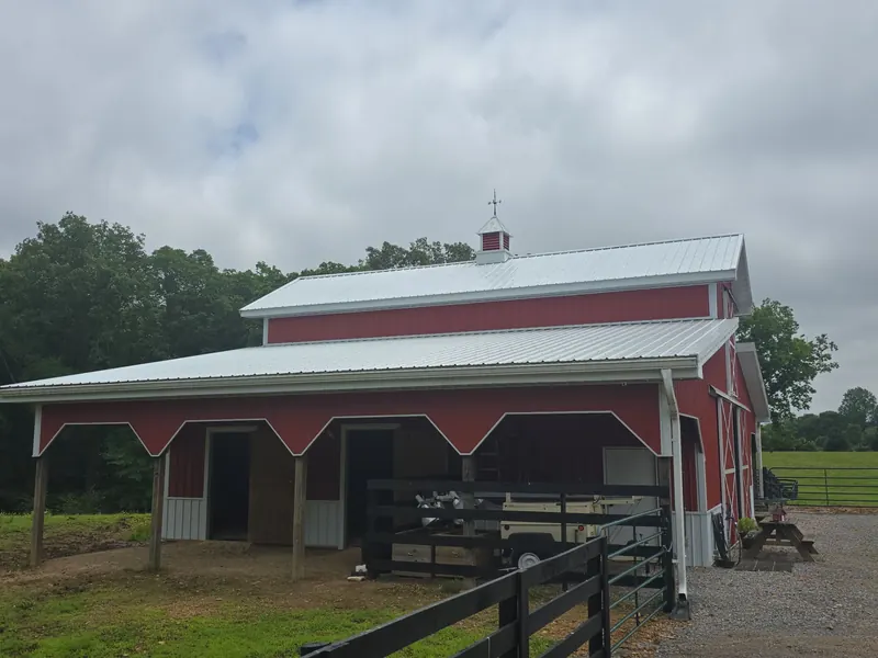 Red barn near New Concord, KY with a white metal roof and cupola