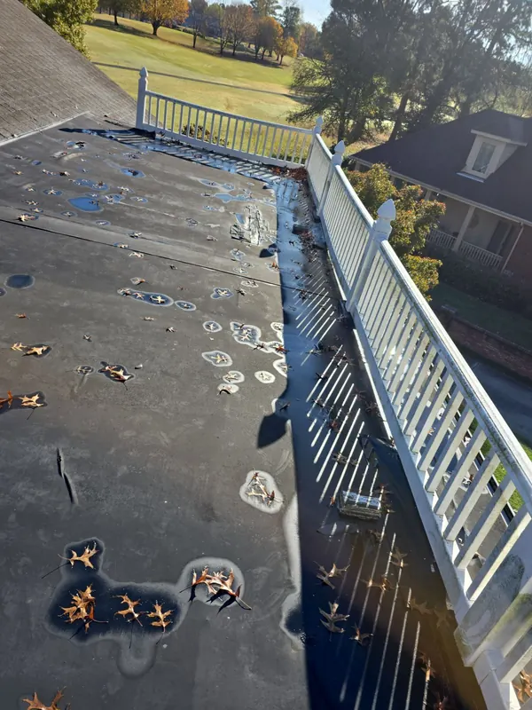 Standing water on an aging flat roof membrane in Mayfield, KY, before replacement