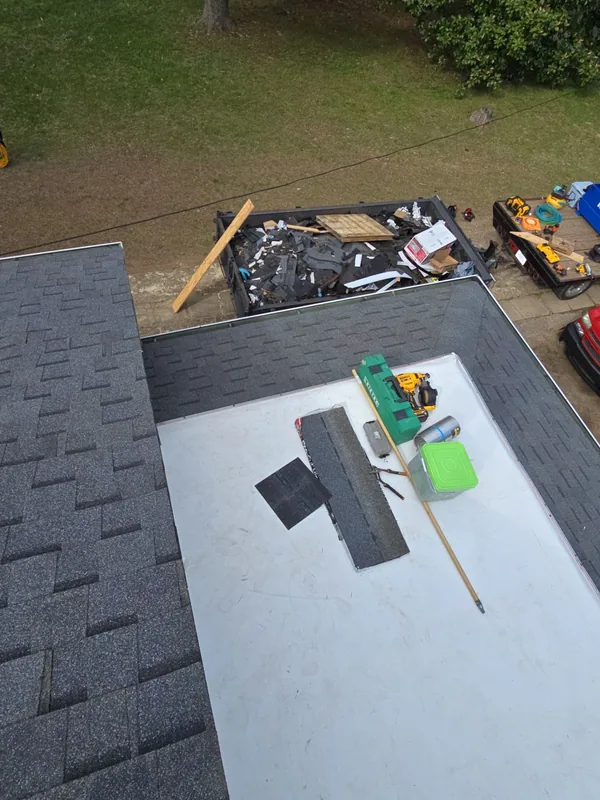 New white membrane on a low-slope roof section beside new architectural shingles in Paris, TN