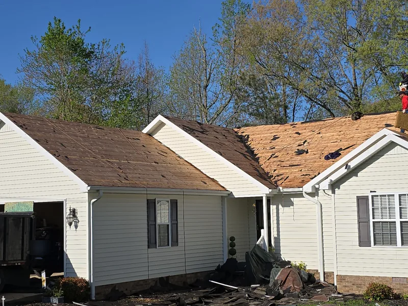 Ranch home in Paris, TN with its old shingles stripped down to the wood decking