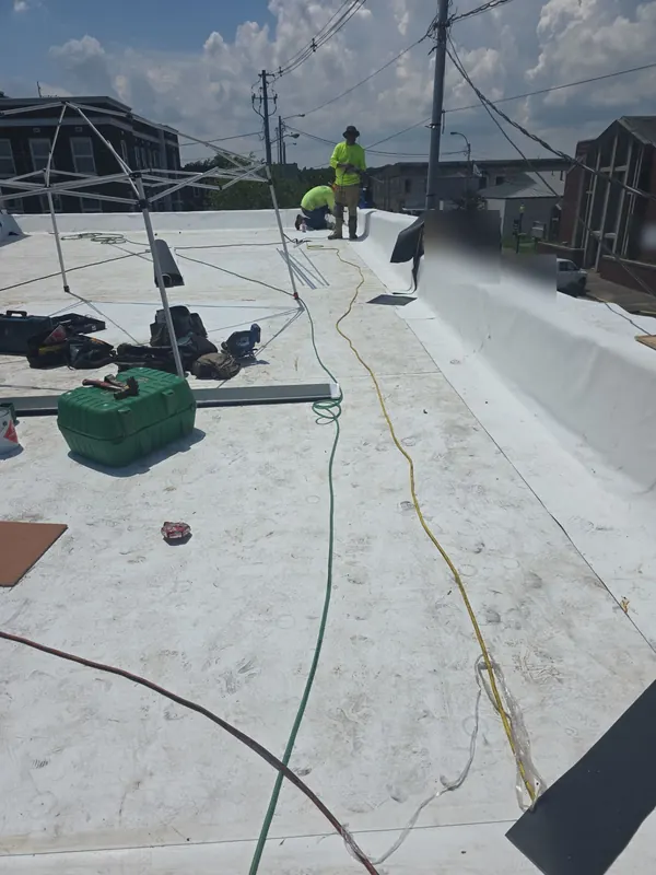 Fit Roofing crew installing white single-ply membrane on a commercial flat roof in Benton, KY