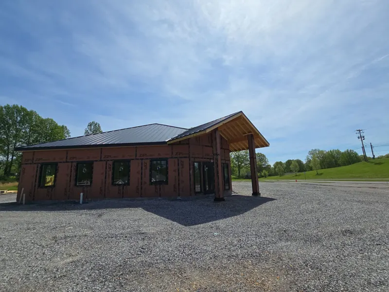 Newly built single-story building in Calvert City, KY with a dark standing-seam metal roof and timber entry canopy