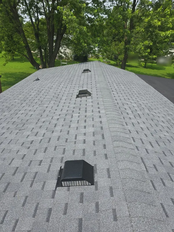 Finished gray architectural shingle roof with ridge cap and box vents in West Paducah, KY