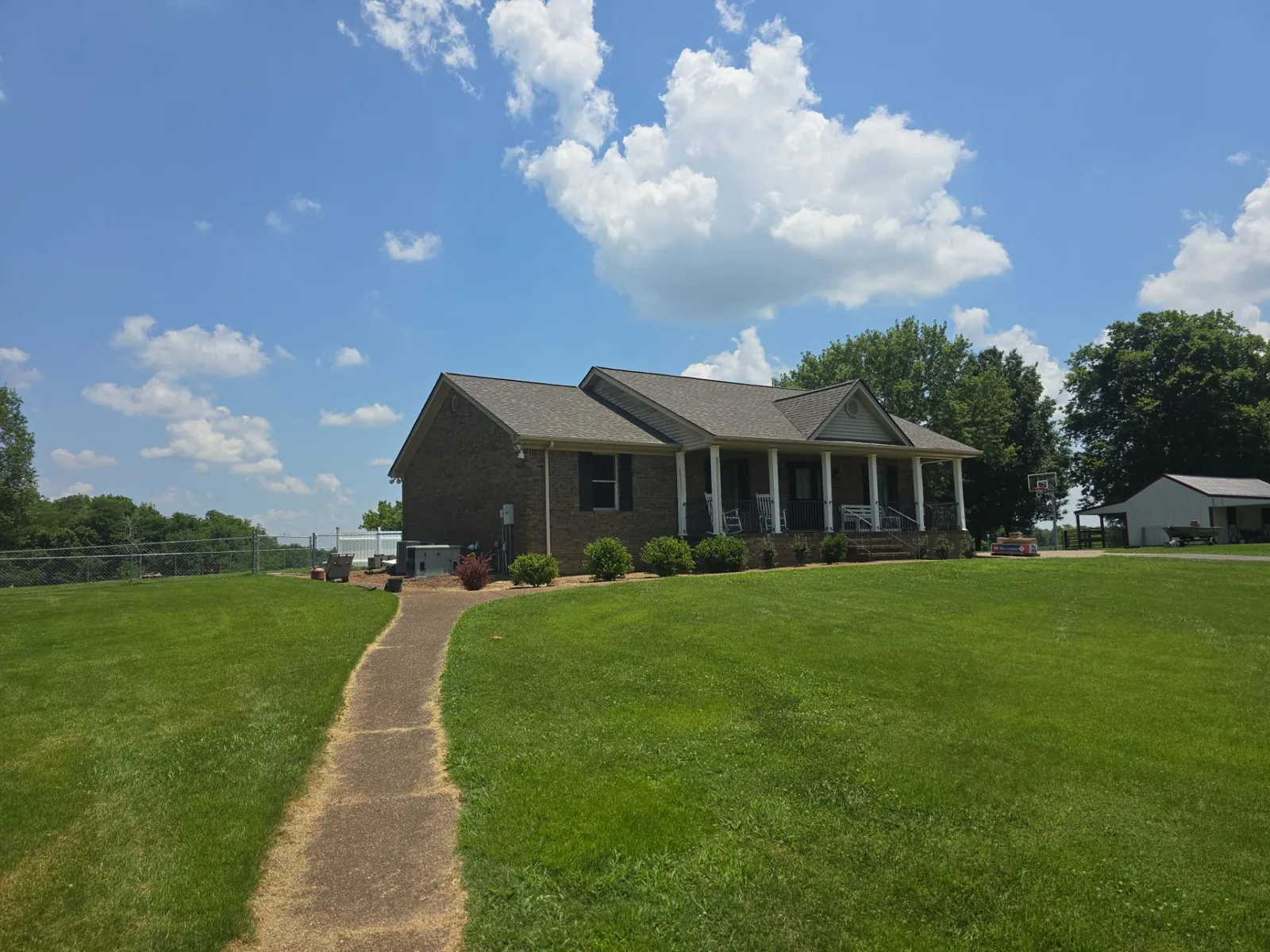 The finished brick ranch home seen from the front walkway with its new architectural shingle roof