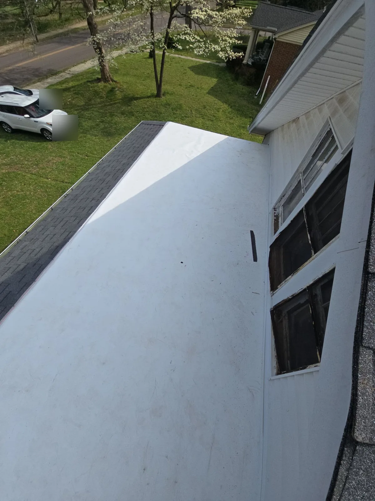 Finished white membrane running the length of the low-slope section next to the new shingle slope