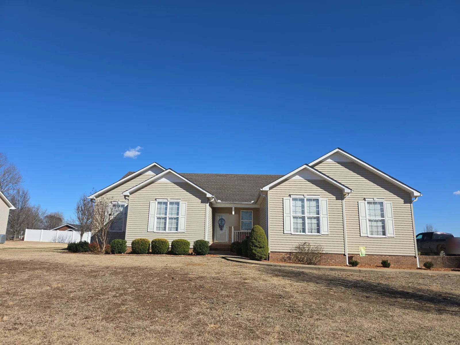 Vinyl-sided ranch home in Paris, TN with its faded, aged shingle roof, before replacement